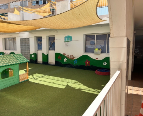 Imagen exterior del centro con moqueta verde y vista a varias aulas