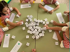 Imagen de varios alumnos jugando con letras del abecedario